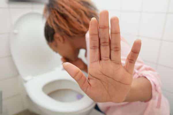 Femme nauséeuse aux toilettes