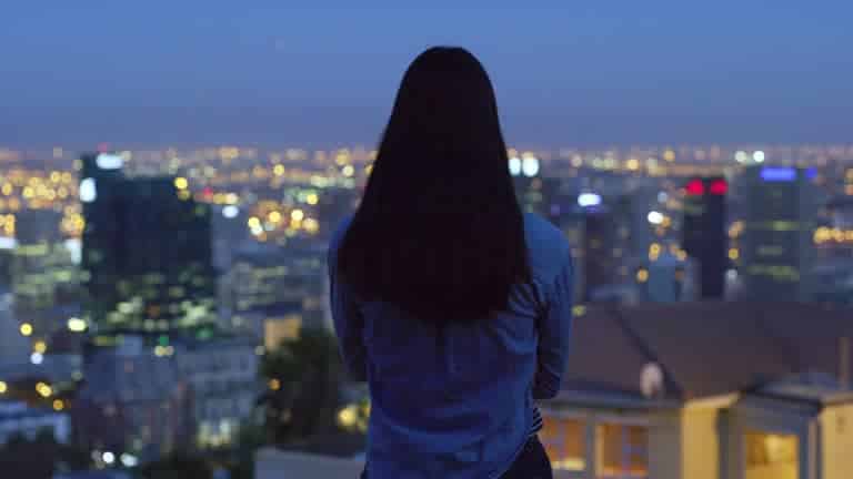 Illustration d'une silhouette féminine devant des lumières de ville