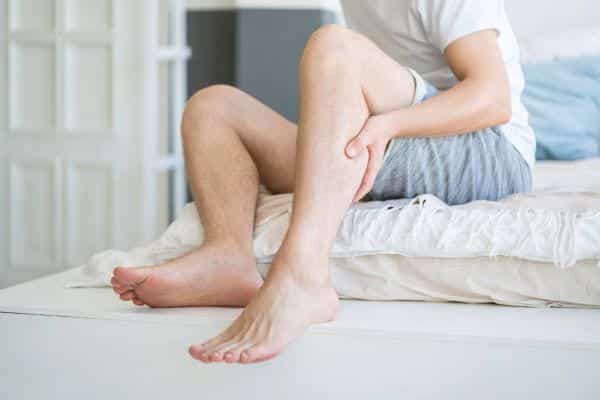 Homme se grattant la jambe