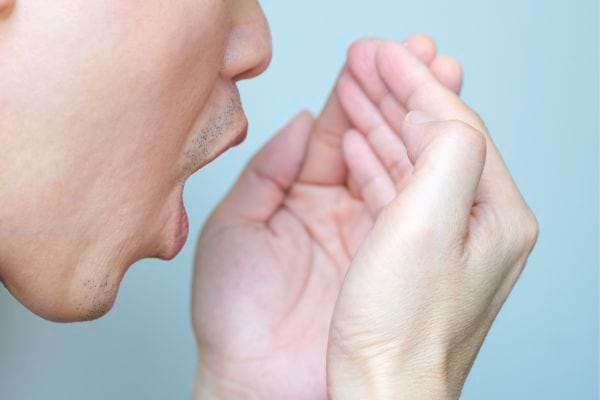 Homme vérifiant son haleine