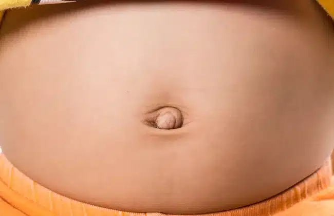 Femme souriante posant la main sur son ventre