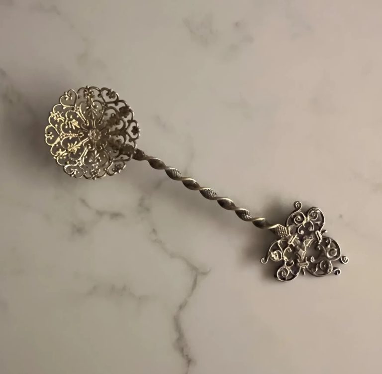 Cuillère à bonbons ancienne posée sur un napperon