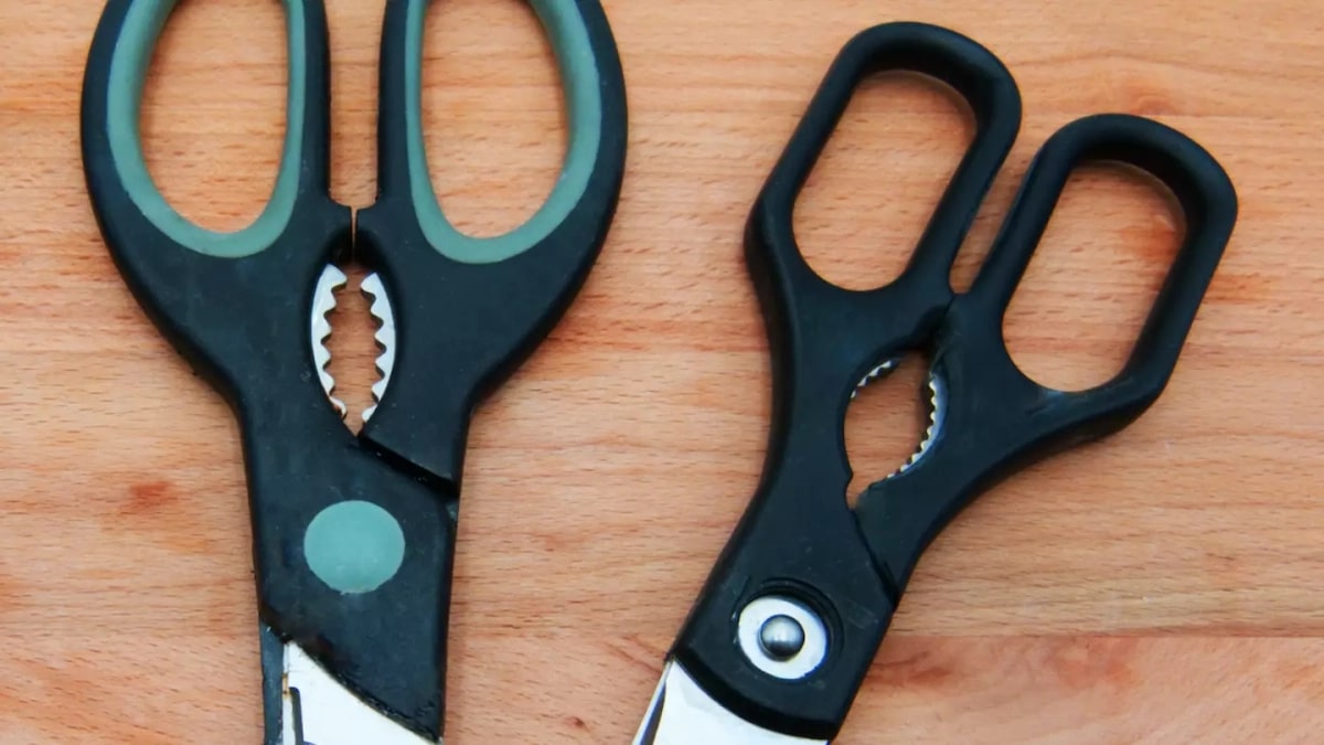 Ciseaux de cuisine pos&eacute;s sur un plan de travail en bois