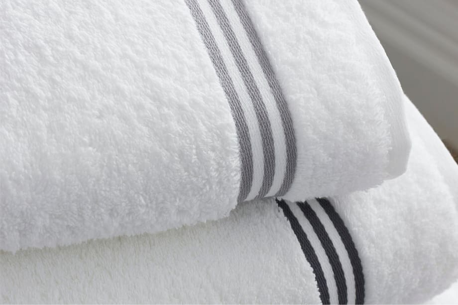 Deux serviettes de bain de couleurs diff&eacute;rentes suspendues c&ocirc;te &agrave; c&ocirc;te