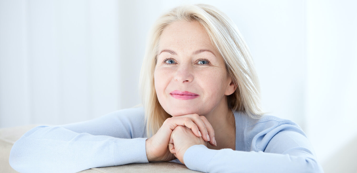 Femme réfléchissant près d'une fenêtre