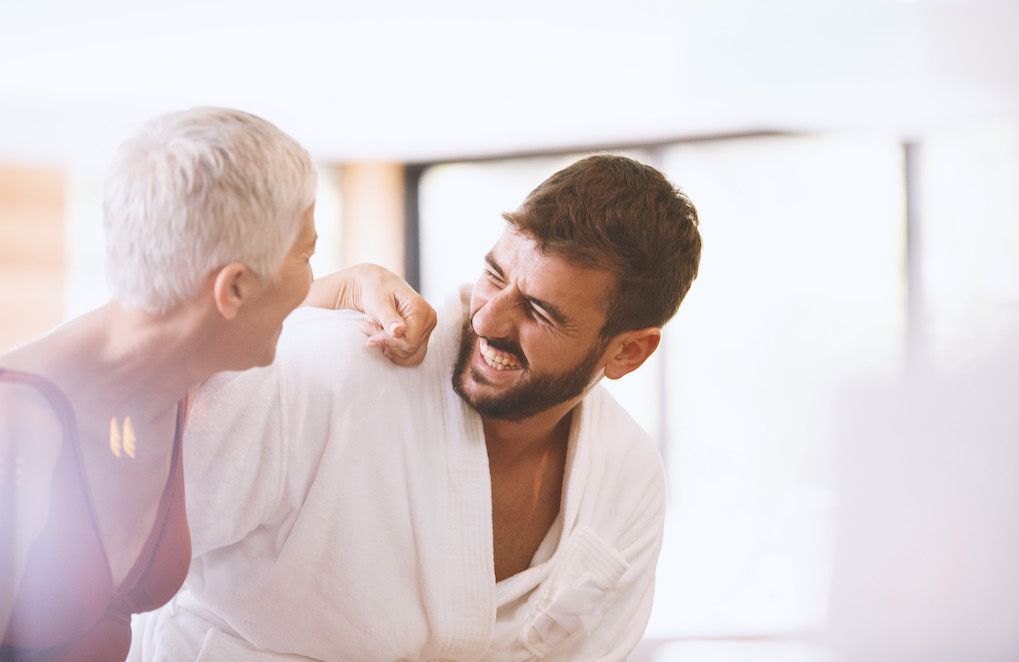 Couple souriant, femme plus &acirc;g&eacute;e et homme plus jeune discutant dans un caf&eacute;