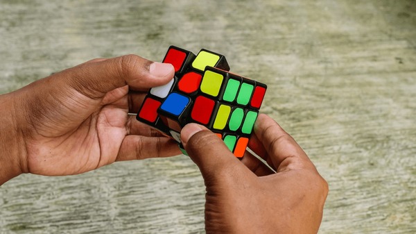 Jeune homme résolvant un Rubik's Cube