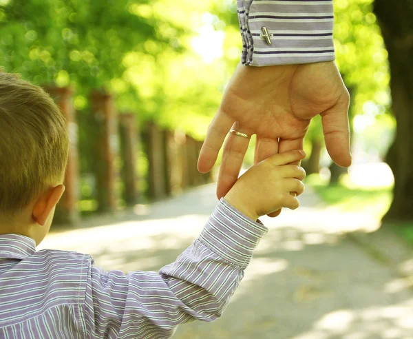 Main d'un adulte tenant celle d'un enfant