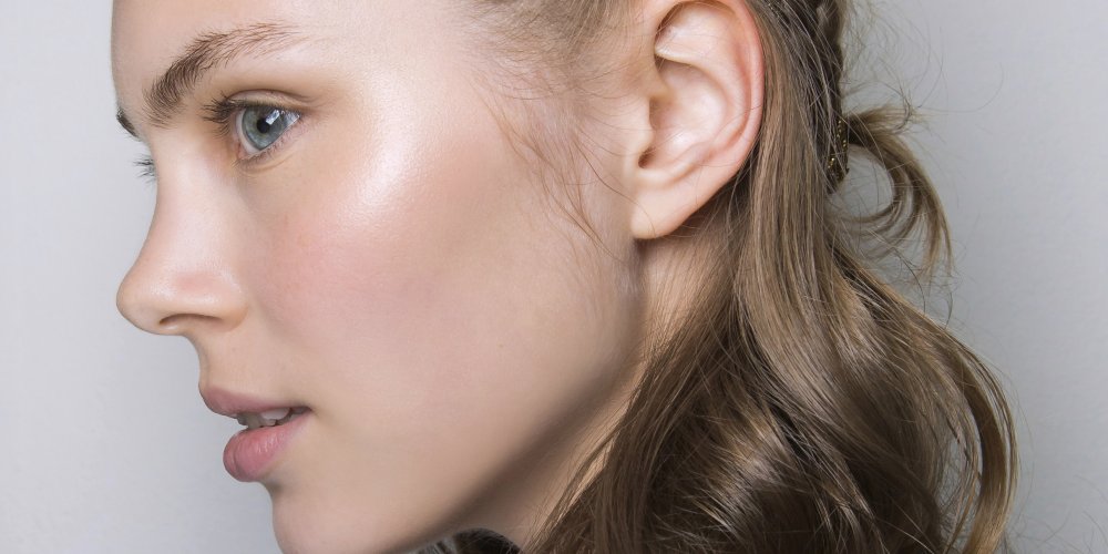 Femme se regardant dans un miroir avec un teint lumineux