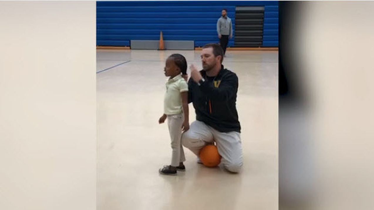 Entraîneur attachant les cheveux d'une jeune joueuse de basket