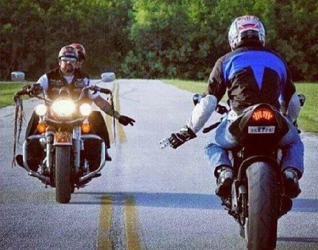 Groupe de motards échangeant des signes sur la route