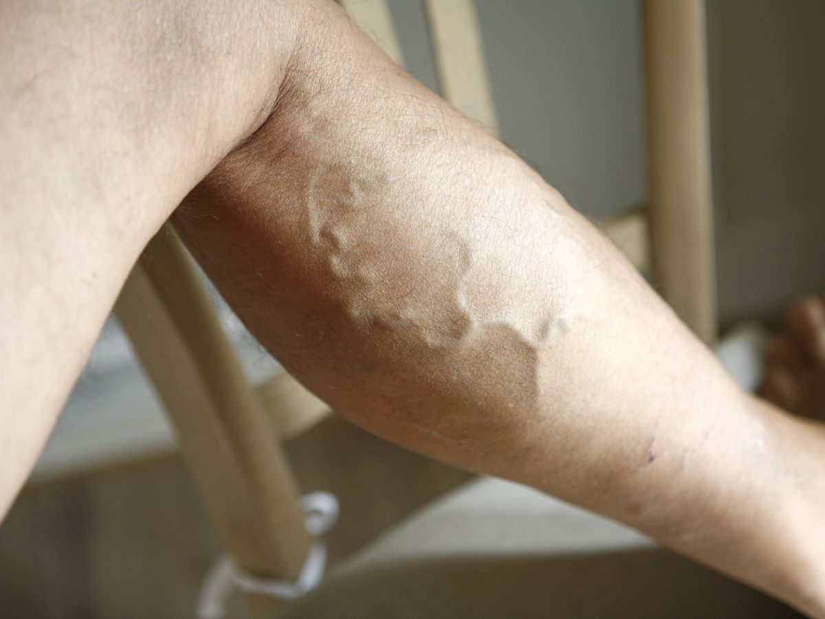 Femme souriante, les jambes surélevées sur un canapé