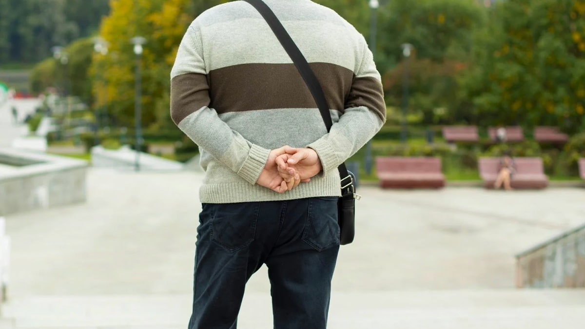 Homme marchant les mains derrière le dos